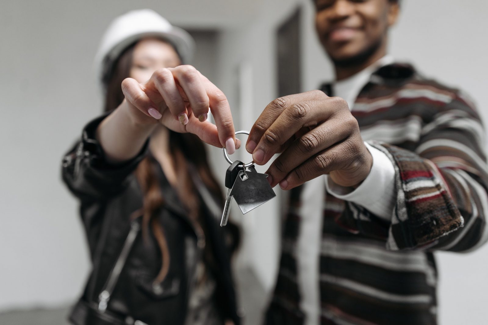 a man and a woman holding the keys of a house