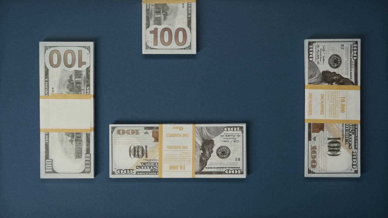 stacks of American dollars on a blue surface