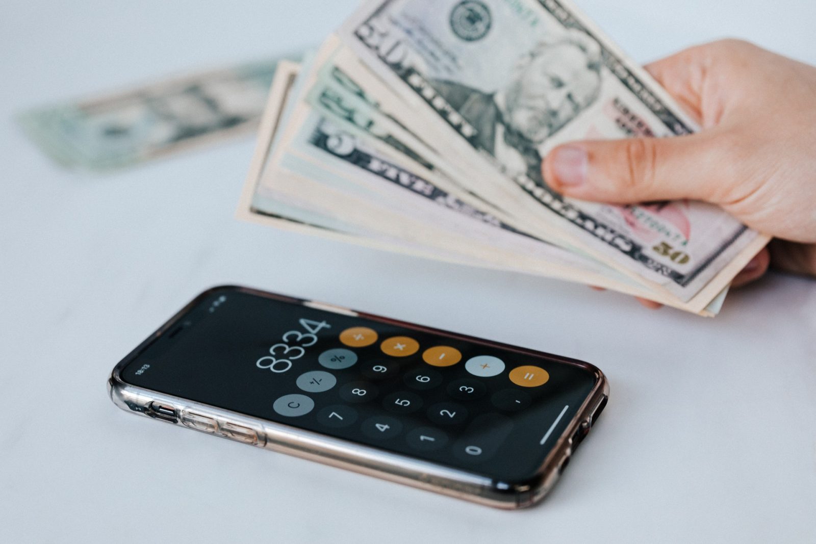 cash money next to calculator on iPhone